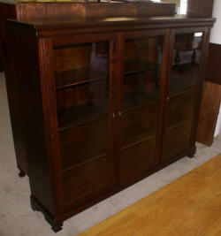 Dark mahogany triple glass door bookcase