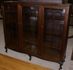 Petite walnut triple glass door antique bookcase