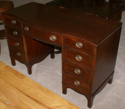 Mahogany pencil inlaid serpentine front antique desk