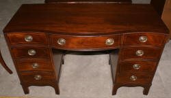 Mahogany pencil inlaid serpentine front antique desk