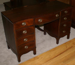 Mahogany pencil inlaid serpentine front antique desk