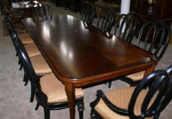 Modern Bassett Cherry dining room table and set of 12 painted black regency dining room chairs